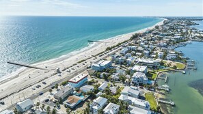 An aerial view of a coastal town with beachfront properties, a pier, and a marina. - Bayview Condo, Unit E - Anna Maria Island - 2 Bedroom/ 2 Bath bay view, maximum occupancy of 4 people. (Bradenton Beach)