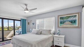 Un dormitorio con cama, mesita de noche y un cuadro en la pared.