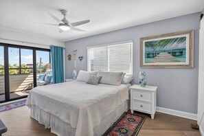 A bedroom with a bed, nightstand, and a painting on the wall. - Bayview Condo, Unit E - Anna Maria Island - 2 Bedroom/ 2 Bath bay view, maximum occupancy of 4 people. (Bradenton Beach)