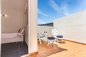 A bedroom with a bed, bedside table, and a small window. - Vacation Apartment 'Roof  Terrace, Pool  Near Beach' with Sea View, Wi-Fi and Air Conditioning (Güímar)