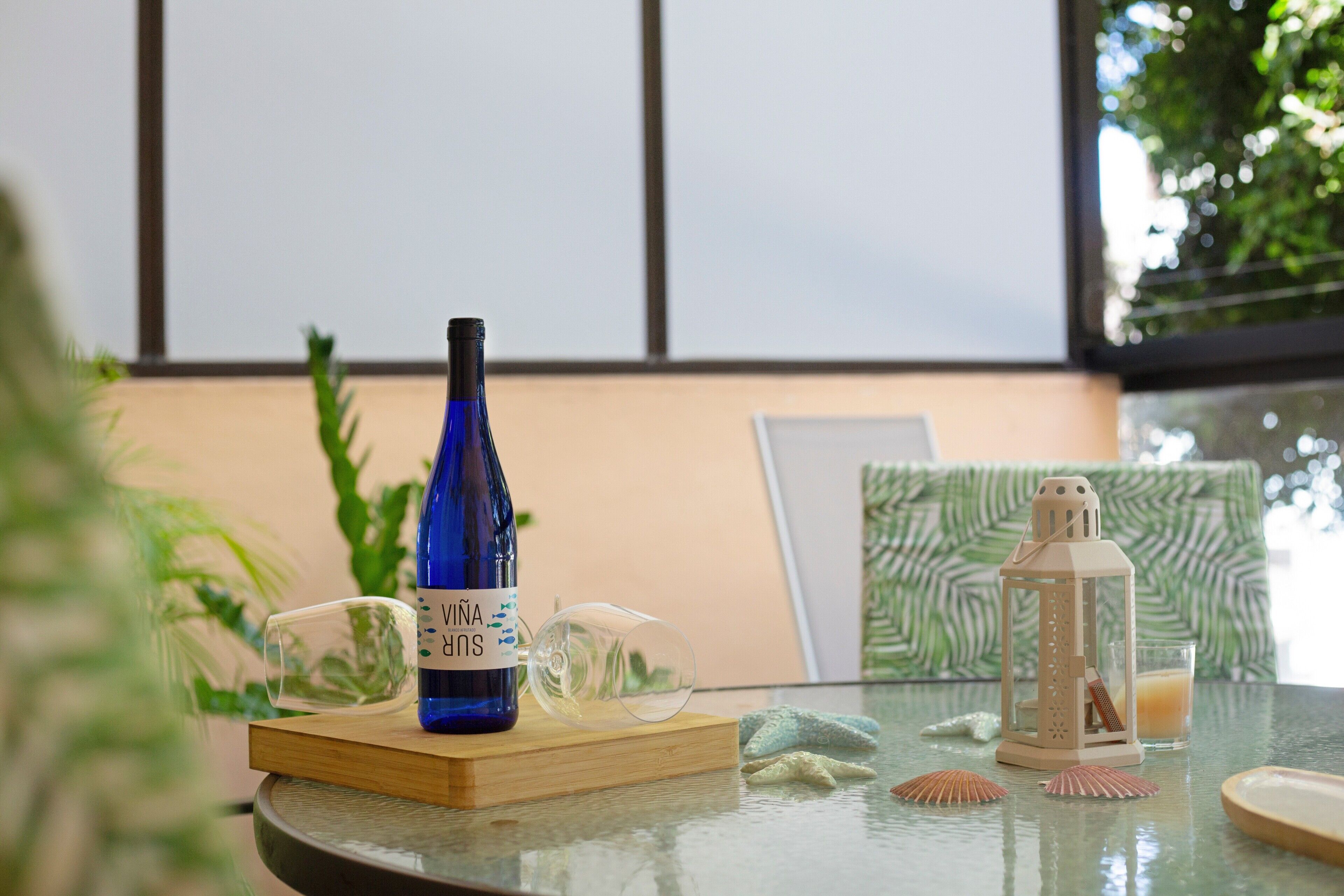 A table with a blue bottle, a glass, a lantern, and decorative items.