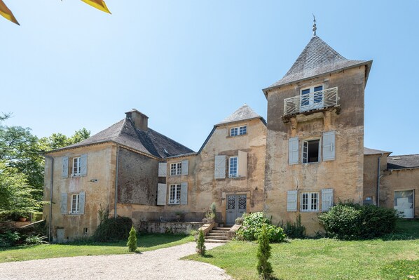 A large stone building with multiple windows and a tower.