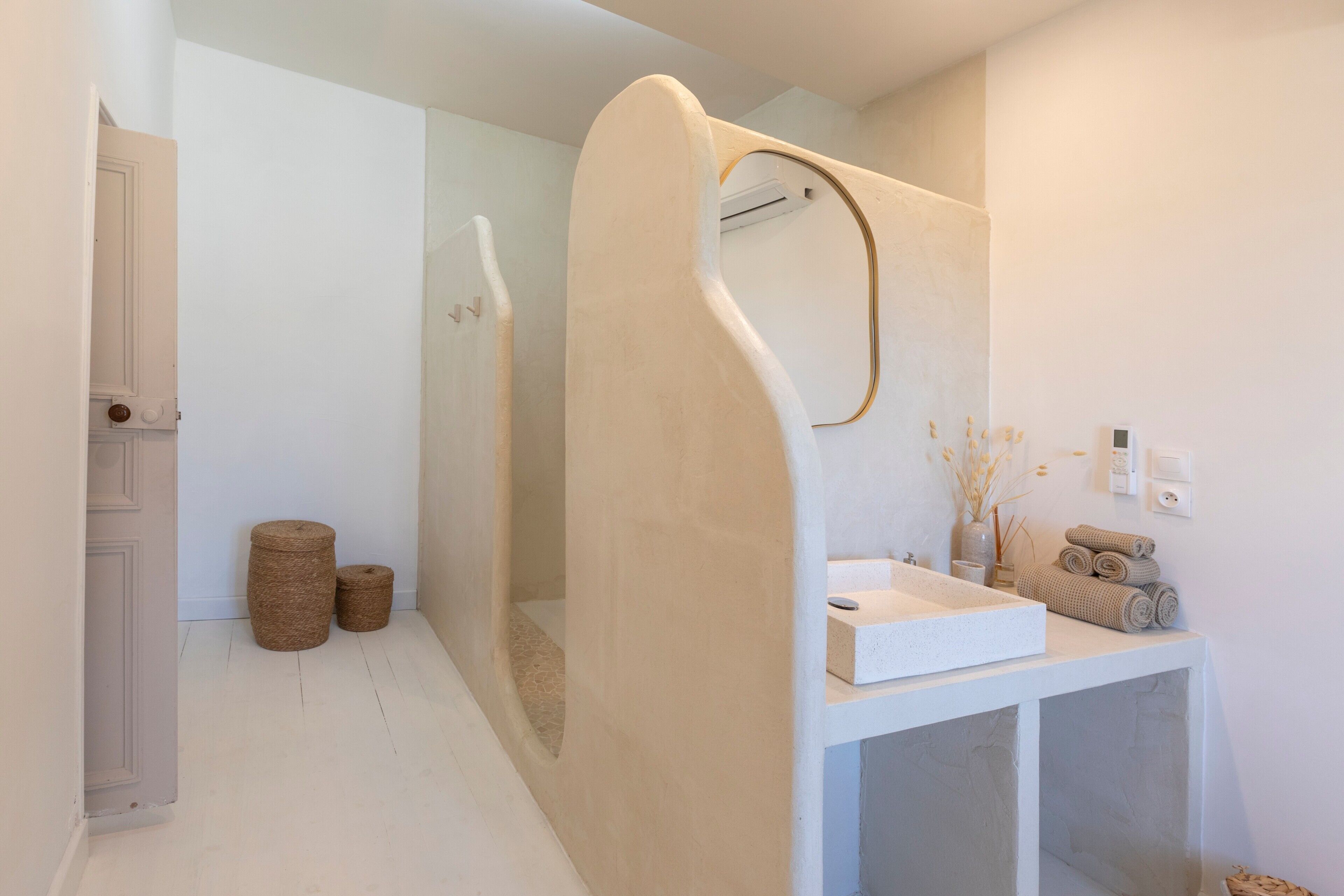 Ein modernes Badezimmer mit Waschbecken, Spiegel und Duschkabine.