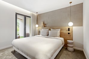 Un dormitorio moderno con una cama grande, cabecera de madera y vistas al exterior.