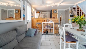 A compact living space with a sofa, dining table, and kitchen area.