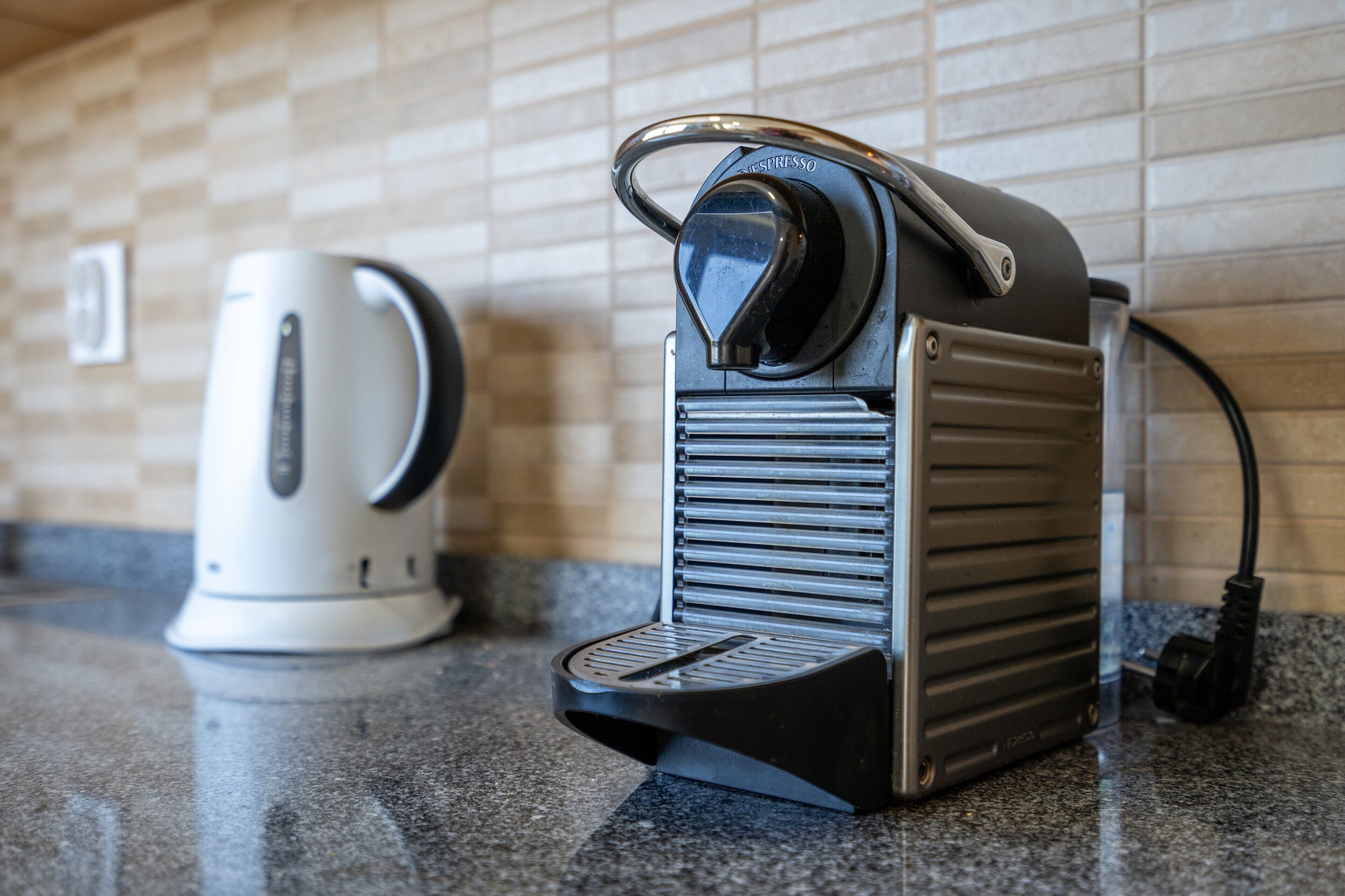 A coffee machine and a kettle on a kitchen counter.