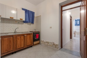 A kitchen with wooden cabinets, a sink, and a stove. - Holiday Home 'Casa Sileno' with Sea View and Wi-Fi (Palermo)