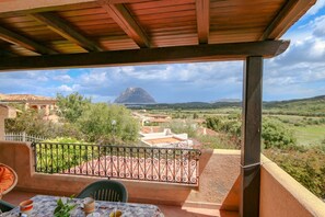 A balcony with a view of a mountainous landscape.