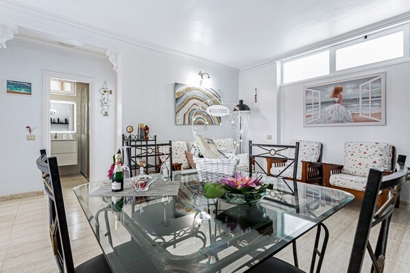 A modern dining area with a glass table, chairs, and a decorative centerpiece.