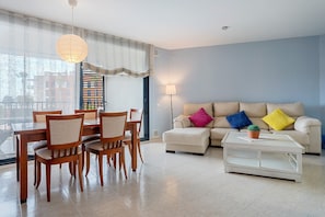 Una sala de estar con una mesa de comedor, sillas, un sofá y una mesa de centro.