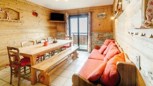 Un intérieur en bois comprenant une table à manger, des bancs et un canapé.