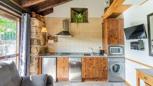 Eine kompakte Küche mit Holzausstattung, inklusive Backofen, Geschirrspüler und Waschmaschine.