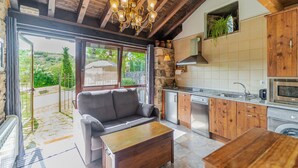 Eine moderne Küche mit Holzausstattung, einem Einbauofen und einer Steinwand.