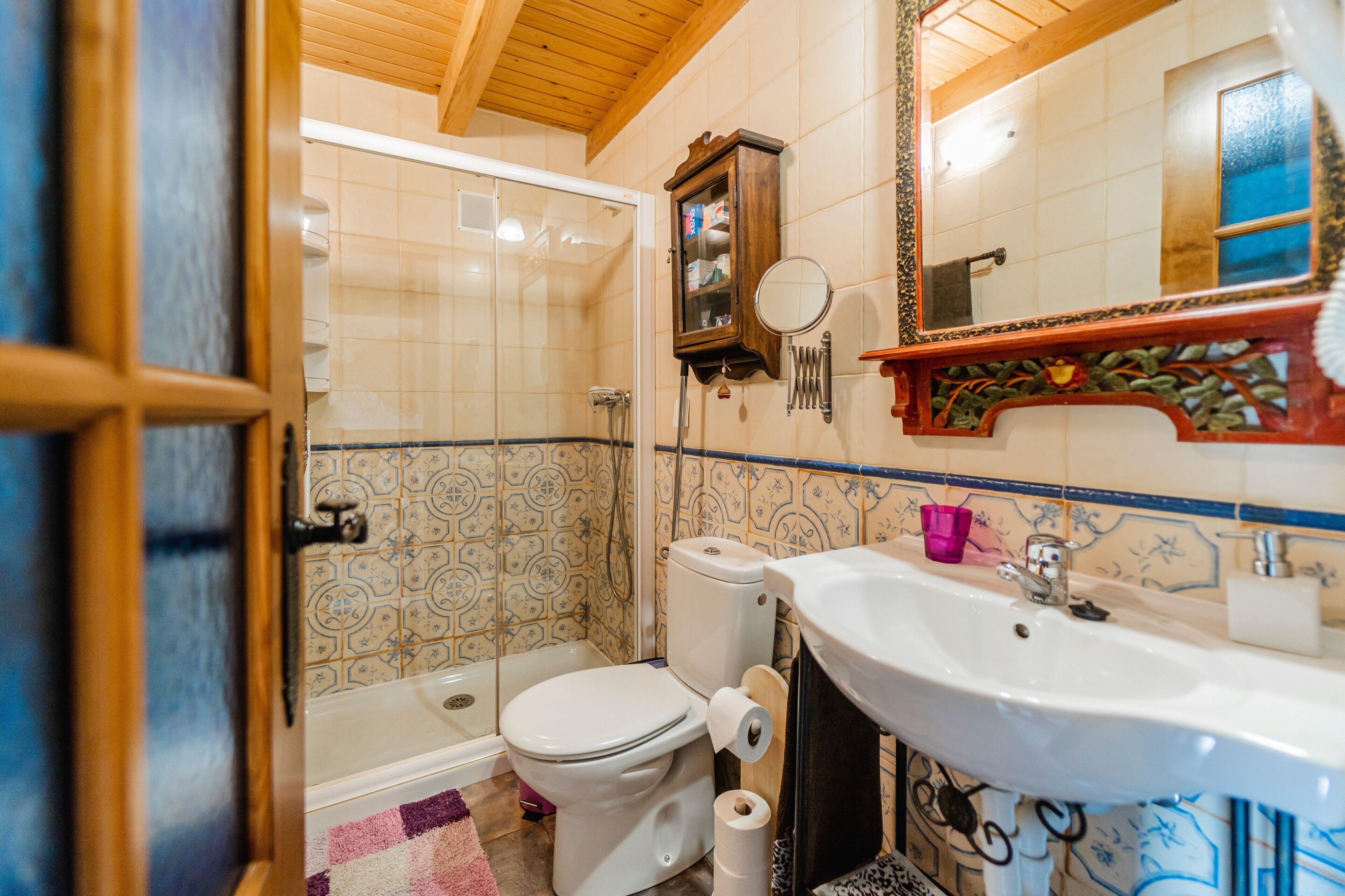 Une salle de bain équipée d’une douche, de toilettes, d’un lavabo et d’un miroir.