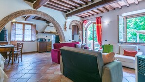 A spacious living area with a kitchen, dining area, and large windows.