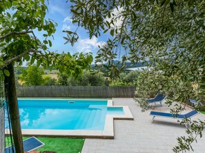 A swimming pool with a clear view of the surrounding landscape, including trees and distant hills.