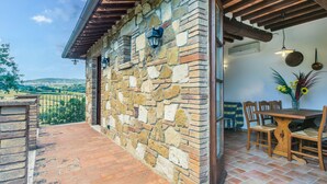 A stone building with a wooden pergola and a patio area.