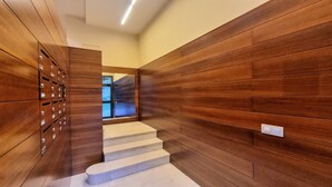 A narrow hallway with wooden paneling on the walls and a set of lockers on the left. - Apartamento Rompeolas (Llanes)