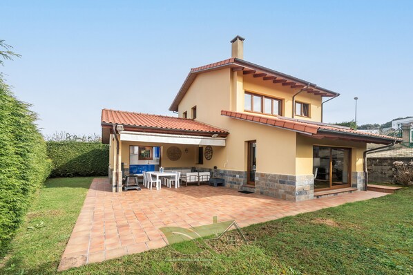 Une maison à deux étages avec un patio, un coin repas et une cuisine.