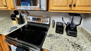 A kitchen with a stainless steel microwave, a stove, a toaster, and a blender. - Arcade + Hot Tub Retreat Sauna Near WPAFB (Dayton)