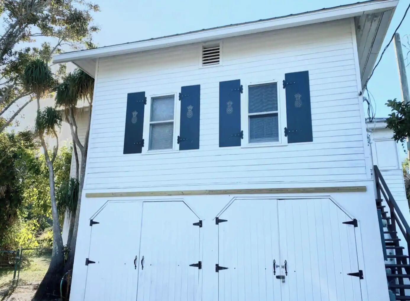 A white building with two windows and a garage door.
