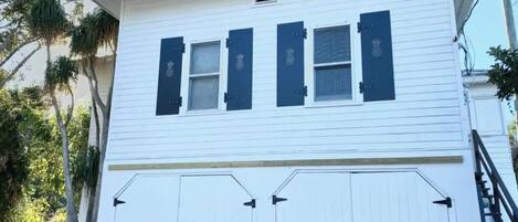 A white building with two windows and a garage door.