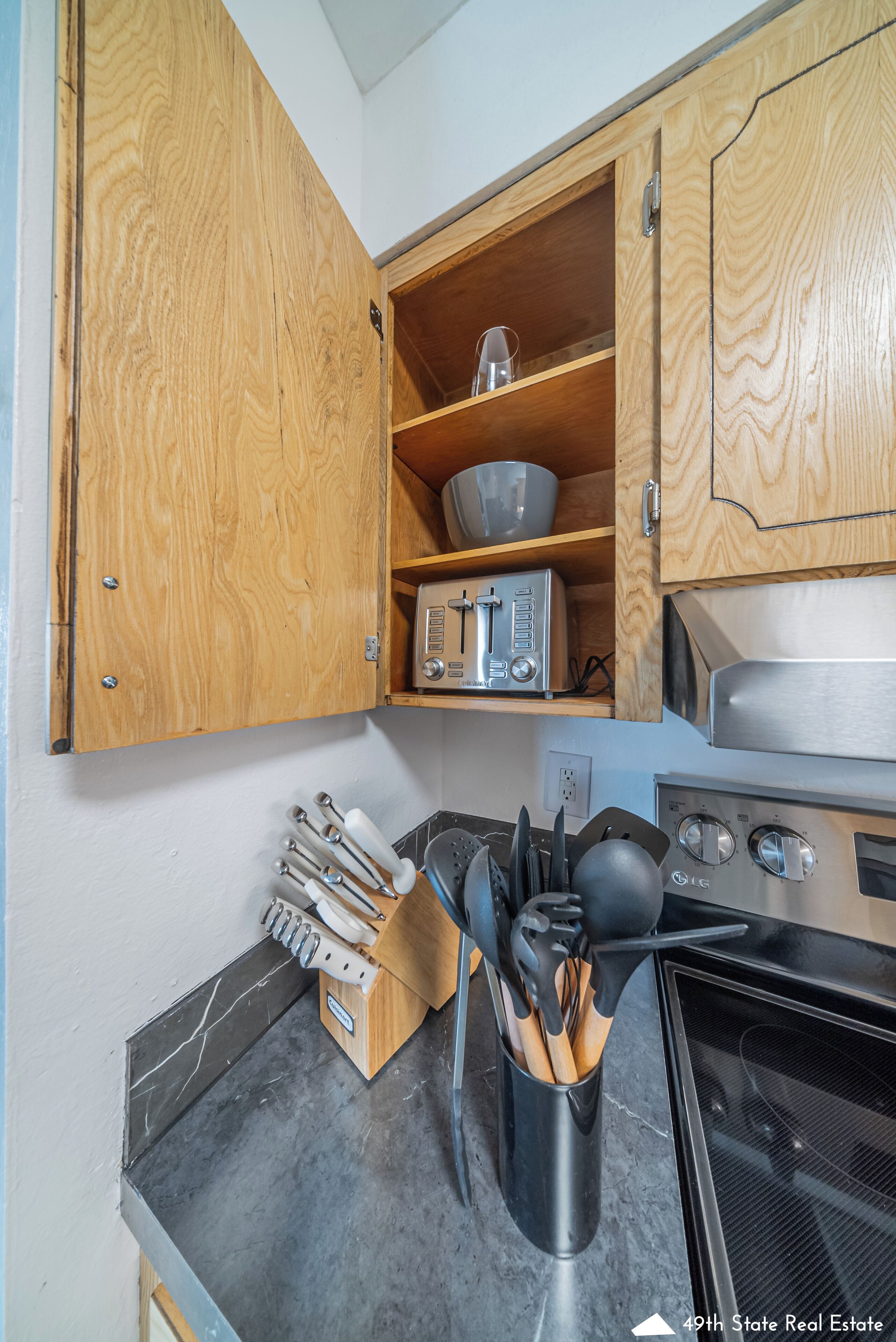 A kitchen with wooden cabinets, a toaster, a microwave, and a stove.