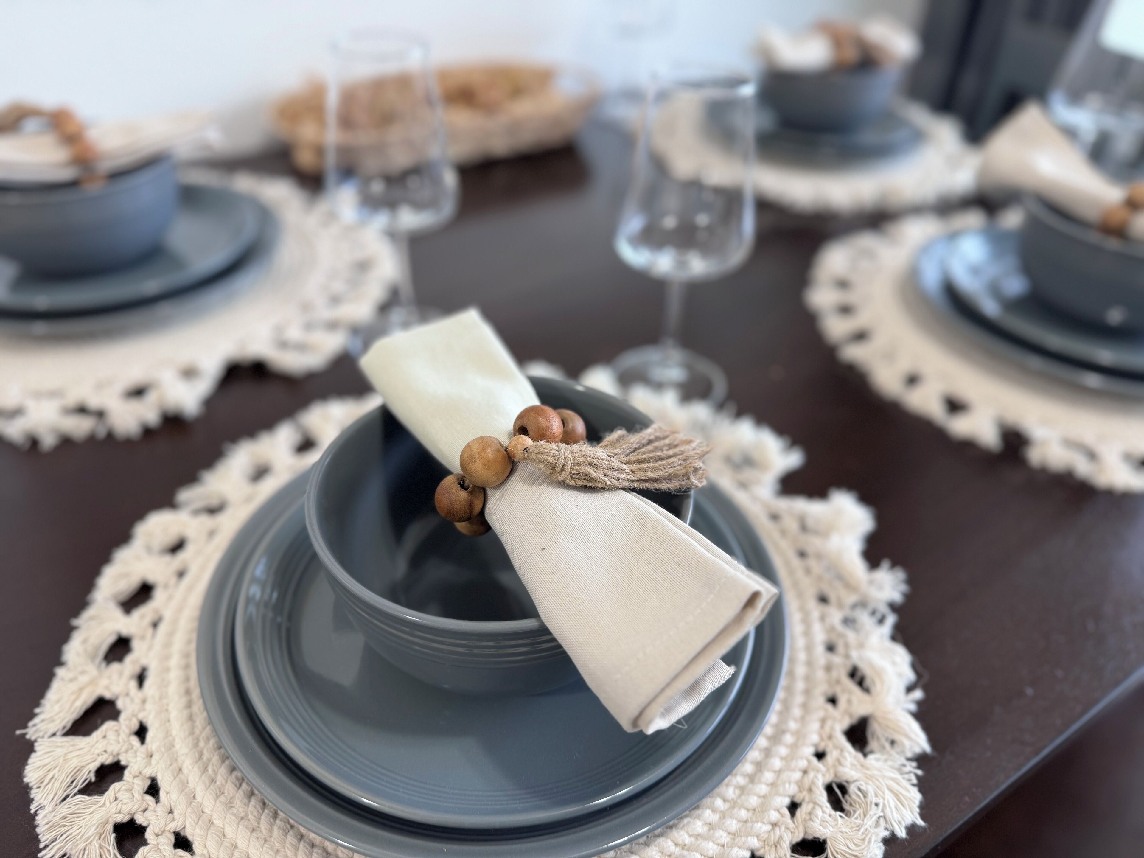 Una mesa servida con platos azules, servilletas blancas y vasos transparentes.