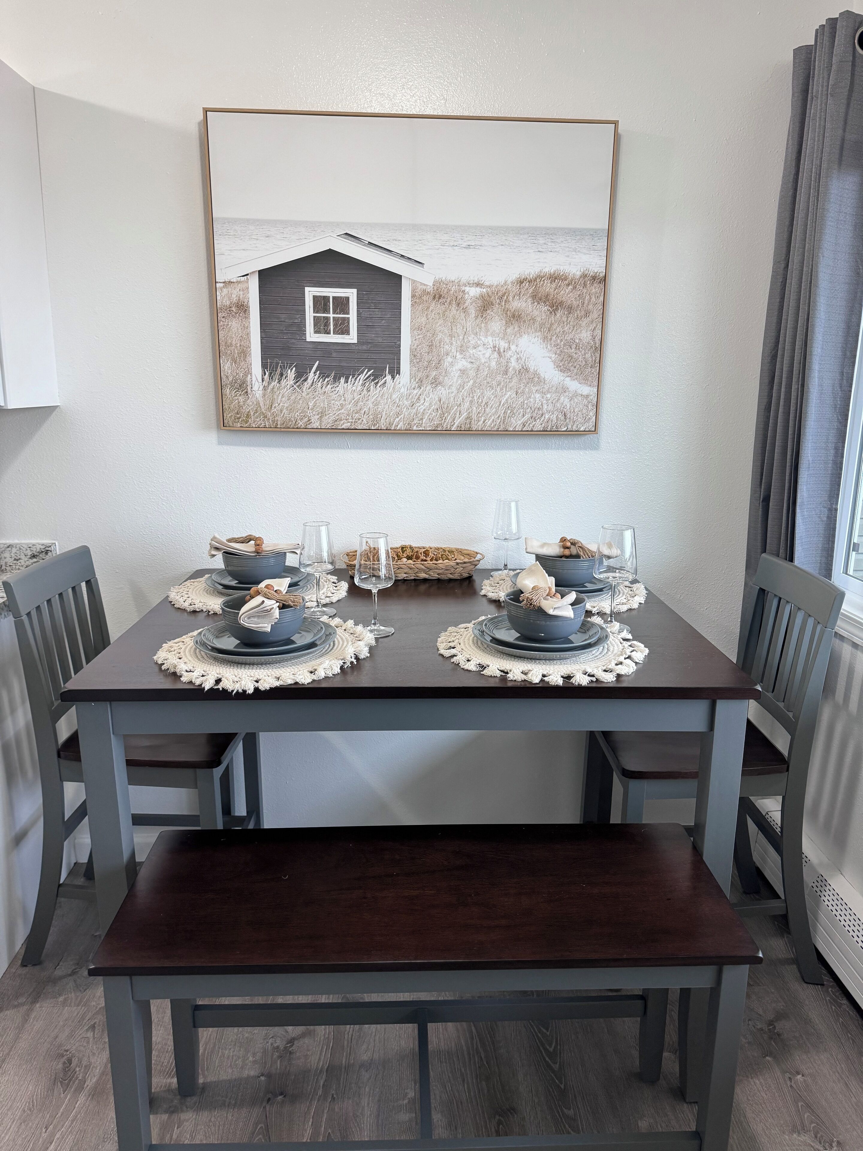 A dining table set with blue plates, bowls, and glasses, surrounded by chairs.