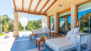 A modern outdoor seating area with a sofa, a dining table, and a lounge chair. - VILLA GOLF MARINA - Charming villa with beautiful garden and private pool. Free Wifi (Pollença)