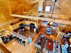 Una cabaña con cocina, comedor y habitación en entrepiso.