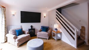 Un salon avec deux canapés, une petite table, une lampe et un escalier.