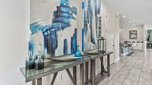 A modern kitchen with white cabinets, a stainless steel countertop, and a large window. - 8BR Modern Family Villa • Game Room • Near Disney (Kissimmee)