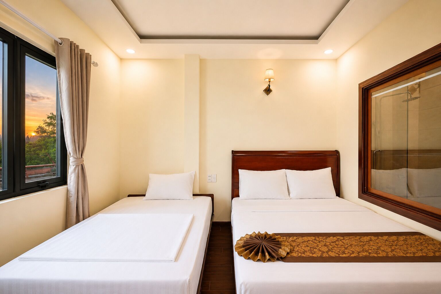 A hotel room with two single beds, a large window with curtains, a wall-mounted lamp, and a view of the outdoors.