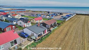 Una zona residencial costera con casas, una playa y vista al mar.