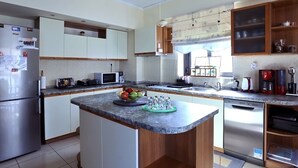 Una cocina moderna con una isla central, electrodomésticos de acero inoxidable y lavavajillas integrado.