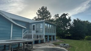 A two-story house with a blue exterior, a front porch, and a small deck. - Fishing camp in Falgout Canal Marina! (theriot)