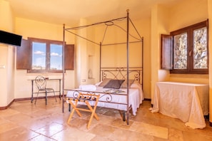 A four-poster bed with a wooden frame, a small table with a white tablecloth, and a chair with a metal frame. - Pagliara Il Morige 8 In The Countryside, Galatone, Italy (Galatone)