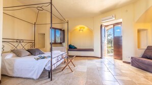 A four-poster bed with a magazine, a bench with cushions, and an air conditioning unit. - Pagliara Il Morige 6 In The Countryside, Galatone, Italy (Galatone)