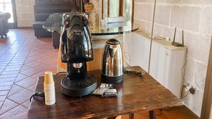 A coffee machine, a kettle, and a stack of cups on a wooden table in a room with tiled flooring and a window. - Pagliara Il Morige 4 In The Countryside, Galatone, Italy (Galatone)
