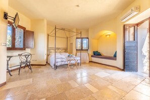A bedroom with a four-poster bed, a window with a view, a seating area with cushions, and a door with a keypad lock. - Pagliara Il Morige 4 In The Countryside, Galatone, Italy (Galatone)