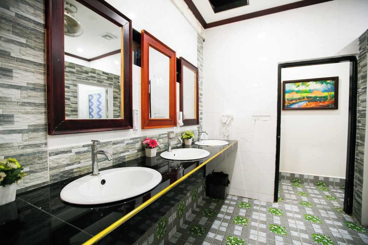 Ein Badezimmer mit zwei Waschbecken, Spiegeln und einem Bild an der Wand.