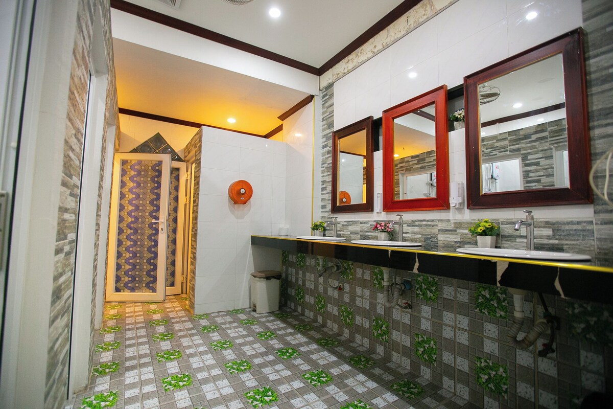 Casa de banho com chão em azulejo, lavatório com espelho e zona de duche.
