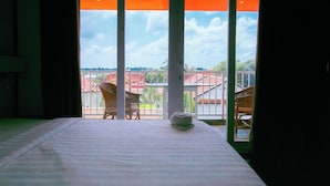 Una habitación con una cama y vistas al exterior a través de un amplio ventanal.