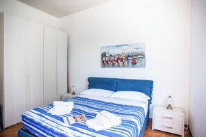 Ein Schlafzimmer mit einem Bett, einem weißen Wandschrank und einem Bild an der Wand.