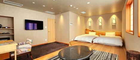 Ein Hotelzimmer mit einem Bett, einem Schreibtisch, einem Fernseher und einem kleinen Tisch.