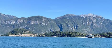 A coastal town with mountains in the background and a boat on the water.