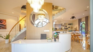 A modern hotel lobby with a reception desk, a staircase, and a bar area. - Pham Gia Villa &Hotel (Xuan Huong - Da Lat)
