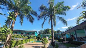 A resort with a pool area, palm trees, and buildings with a green facade. - Tum Mai Kaew Lanta Resort (Ko Lanta)