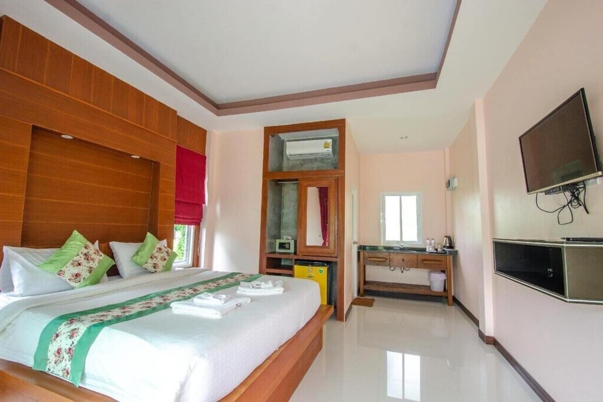 A hotel room with a bed, a TV, a desk, and a bathroom.